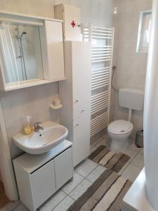 Baño blanco con lavabo y aseo en Apartman Verona en Ilok