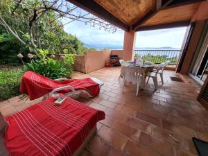 un patio con tavolo e sedie su un patio in mattoni di Maison Les couchants Porticcio a Porticcio