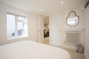 a white bedroom with a white bed and a window at Garden View in Worthing