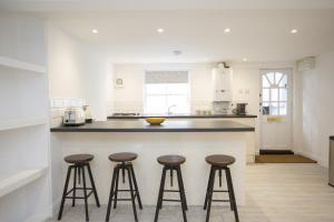 a kitchen with three bar stools at a counter at Garden View in Worthing