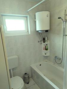 a bathroom with a tub and a toilet and a sink at Apartman Verona in Ilok