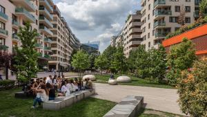 a group of people sitting on a concrete bench in a courtyard at Feel Home DeLuxe CORVIN # FREE PARKING # AC # Elevator in Budapest