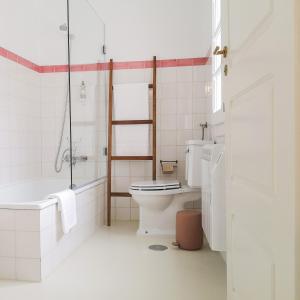 a bathroom with a toilet and a tub and a sink at Casa do Pátio, casaspensadas in Juncal