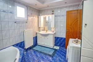 a bathroom with a tub and a sink and a toilet at Villa George in Nea Peramos +22 photos