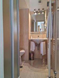 uma casa de banho com um lavatório, um WC e um espelho. em Hotel Virgilio em Orvieto