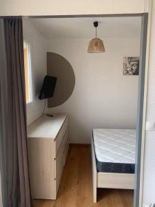 1 dormitorio con cama, escritorio y ventana en Appart 5 pers port de Gruissan, en Gruissan