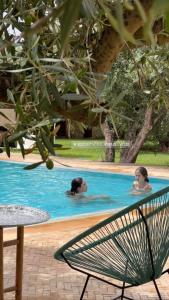 2 personnes nagent dans une piscine dans l'établissement Upupa de l’Atlas, à Marrakech