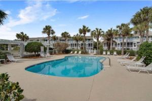 una piscina con tumbonas y un complejo en Beach Club Villa 32 - Newly Renovated! Direct Oceanfront, en Isle of Palms