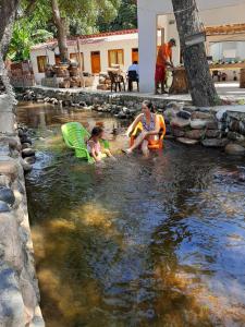 una mujer y dos niños jugando en un río en Hotel Distracción Guajira, en Fonseca