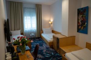 Habitación de hotel con 2 camas y mesa en Hotel Etol - Superior, en Baden-Baden
