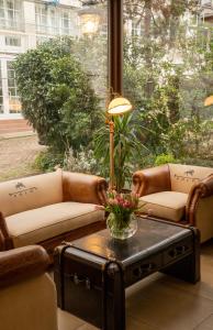 una sala de estar con dos sofás y una mesa con flores. en Hotel Etol - Superior, en Baden-Baden