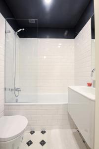 a bathroom with a tub and a toilet and a sink at Charming Studio in central Lisbon in Lisbon