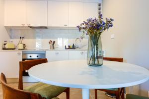 a vase of flowers on a white table in a kitchen at Charming Studio in central Lisbon in Lisbon