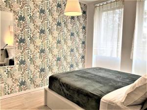 een slaapkamer met een bed met bloemenbehang bij Zurigo 3 Lovely Apartment in Milaan