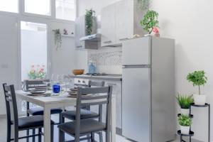 eine Küche mit einem Tisch mit Stühlen und einem Kühlschrank in der Unterkunft Tropical - Boutique Apartment in Gallipoli