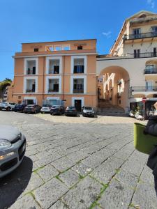 un gran edificio con coches estacionados frente a él en Serendipity, en Gaeta