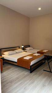 Pokój z 2 łóżkami i biurkiem z biurkiem w obiekcie Polifonia Inn Borjomi w Bordżomi