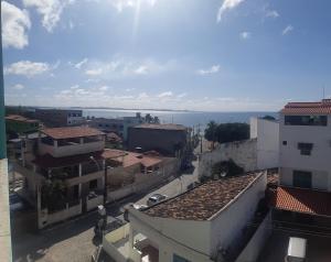 uma vista para uma cidade com edifícios e o oceano em Pousada 4 estações em Madre de Deus