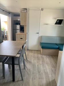 - une cuisine et une salle à manger avec une table et des chaises dans l'établissement Mobil home Camping 4* La Falaise Narbonne Plage, à Narbonne-Plage