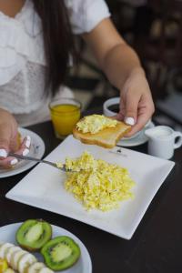 a person holding a plate of eggs and toast at Hotel Alma De Buenos Aires in Buenos Aires