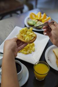 a person holding a piece of toast with eggs on it at Hotel Alma De Buenos Aires in Buenos Aires