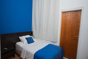 a small bedroom with a bed with a blue background at Hotel Alma De Buenos Aires in Buenos Aires