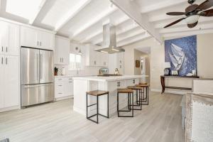 a large kitchen with white cabinets and bar stools at 114 Forty-Second Street A in Newport Beach
