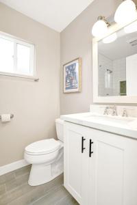 a white bathroom with a toilet and a sink at 114 Forty-Second Street A in Newport Beach +37 photos