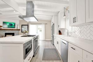 a white kitchen with white cabinets and a fireplace at 114 Forty-Second Street A in Newport Beach