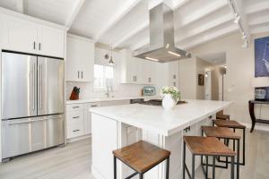 a kitchen with white cabinets and a large island with stools at 114 Forty-Second Street A in Newport Beach