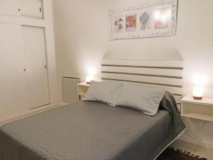 Un dormitorio con una cama con dos mesas y dos lámparas. en Casa de los Loles Tandil, en Tandil