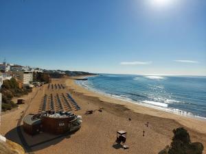 een strand met een stel stoelen en de oceaan bij Candyland Apartment in Albufeira