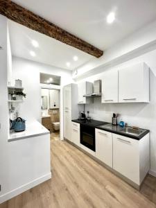 eine Küche mit weißen Schränken und schwarzen Arbeitsplatten in der Unterkunft Chez Thibault brandnew one bedroom apartment in Antibes in Antibes