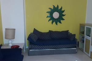 a living room with a blue couch and a mirror at BILOCALE CON VISTA MARE E MON in Cala Gonone