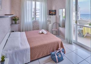 a bedroom with a bed and a balcony with the ocean at Marittima Rooms in Milano Marittima