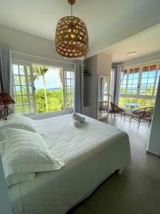 a bedroom with a large bed and a large window at Hotel Pousada 7 Mares in Itapema +53 photos