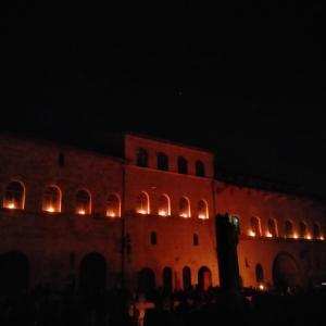 un edificio con luci sul lato di esso di notte di Appartamenti Santa Chiara ad Assisi