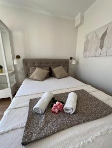 a bedroom with a bed with two pillows and flowers at Studio apartman Nela in Murter