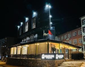 um edifício com luzes em cima à noite em GRAND JNK Boutique Hotel em Kukës