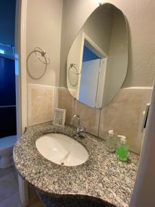 a bathroom with a sink and a mirror at Pousada Vila Tadeu in São João Batista do Glória