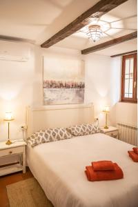 - une chambre avec un grand lit blanc et deux lampes dans l'établissement Hammam de Zeid, à Tolède