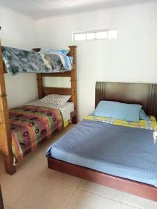 Finca de descanso Amai Haru Jenesano في Jenesano: غرفة نوم بسريرين بطابقين وسرير صغير