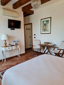 a bedroom with a white bed and a table and chairs at Casa Pianta in Cavallino-Treporti