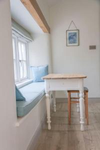 um quarto com uma mesa e uma janela com um banco em BARLEY - cosy stylish apartment - easy access to Bath and many nearby attractions em Box