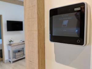 a television on the wall of a room at BARLEY - cosy stylish apartment - easy access to Bath and many nearby attractions in Box