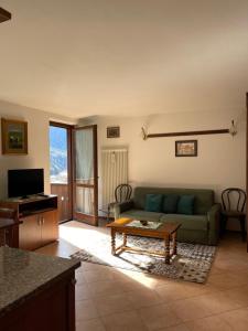 een woonkamer met een bank en een tafel bij Rosadira Vista Lago sulle Dolomiti in Auronzo di Cadore