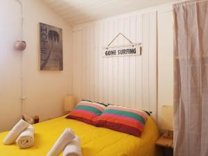 Un dormitorio con una cama amarilla con toallas. en Guesthouse Évasion, en Contis-les-Bains