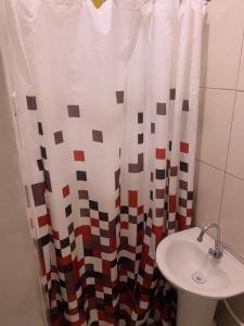 bagno con lavandino e tenda doccia di Hotel Pousada AngraAntiga ad Angra dos Reis