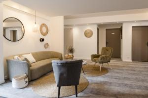 a living room with a couch and two chairs at Logis Beaujoire Hôtel in Nantes