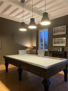 a pool table in a room with two lights at Château Bernon Maison d Hotes - Piscine et sauna in Queyrac